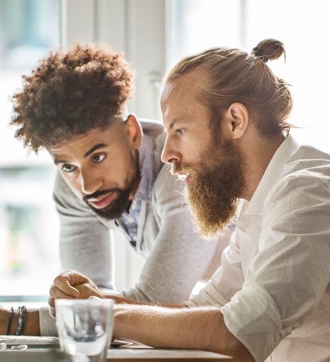 Dos consultores de CORE OPS analizando información en pantalla